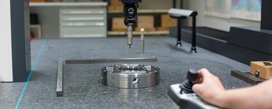 Mitarbeiter kontrolliert Produkt auf der 3D-Messmaschine